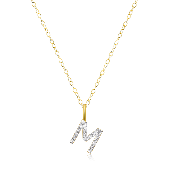 A diamond initial M pendant on gold chain on a white background