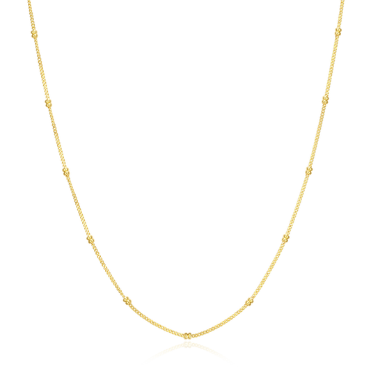 Gold chain necklace with small gold stationed beads on a white background