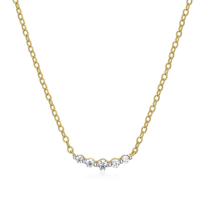 A gold necklace with five graduated diamonds on a curved bar on a white background