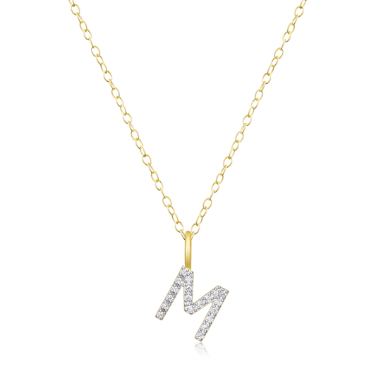 A diamond initial M pendant on  gold chain on a white background