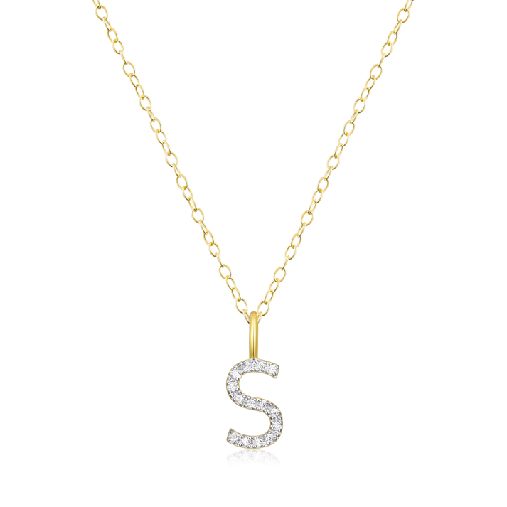 A diamond initial S pendant on  gold chain on a white background