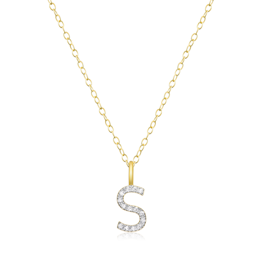 A diamond initial S pendant on  gold chain on a white background