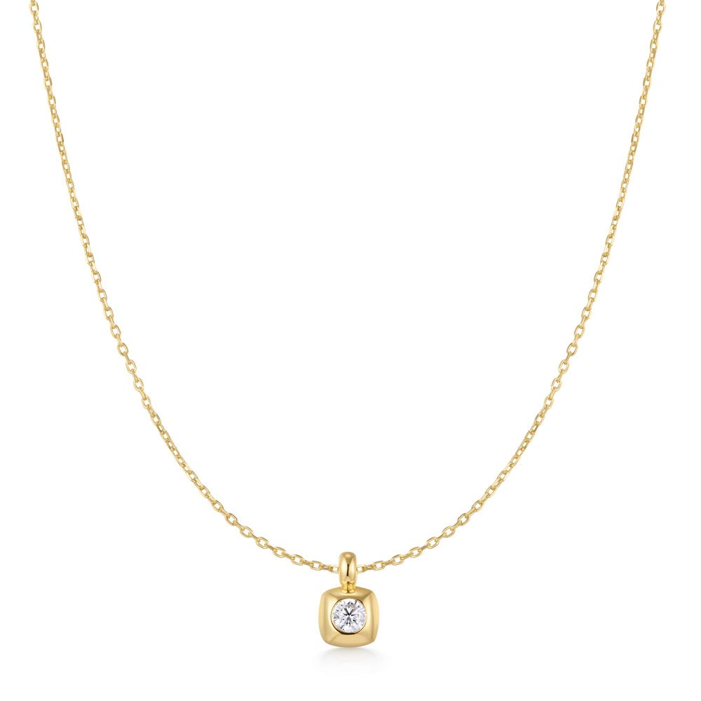 yellow gold plated pendant on a chain with a clear stone on a white bacground